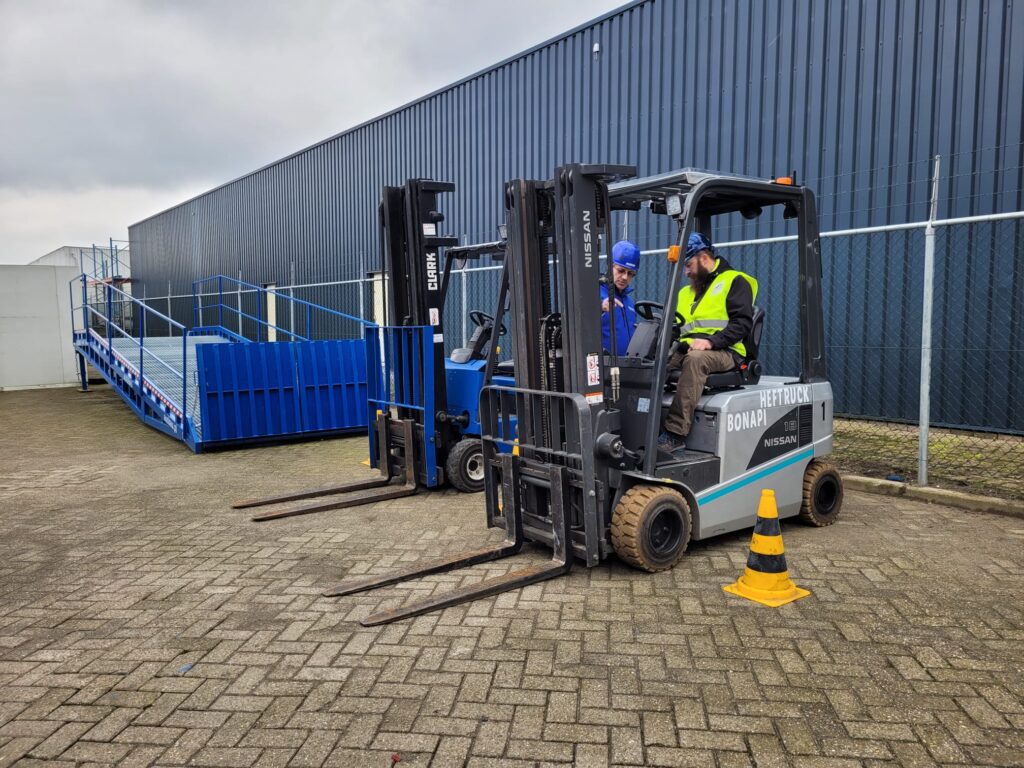 Podczas szkolenia w Bonapi Training Center instruktor tłumaczy kursantowi obsługującemu wózek, jak wygląda prawidłowa obsługa wózka widłowego – huftruck.